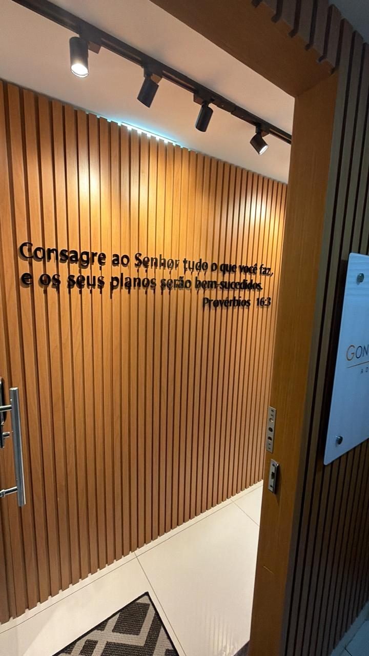 Hall de entrada do escritório, com versículo de Provérbios 16:3 na parede